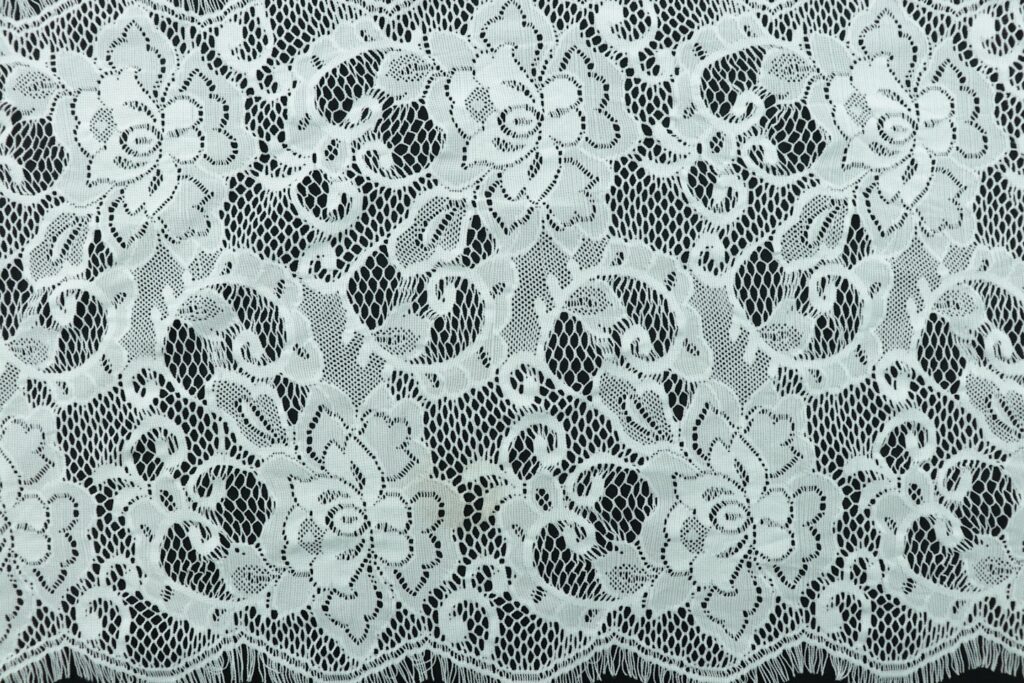 a close up of a white lace on a black background